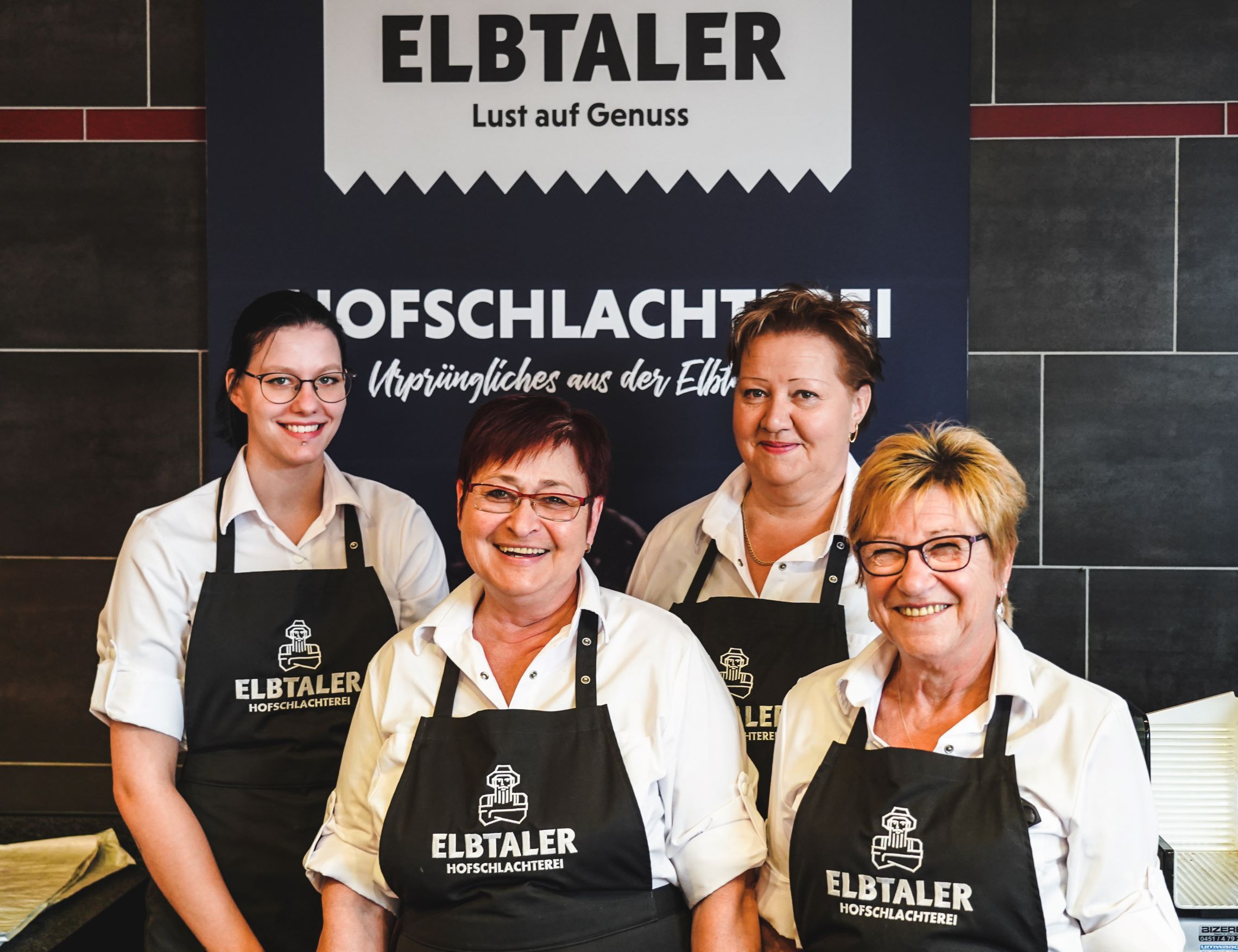Amt Neuhaus Vier Damen stehen vor einem Elbtaler Banner und lächeln in die Kamera.