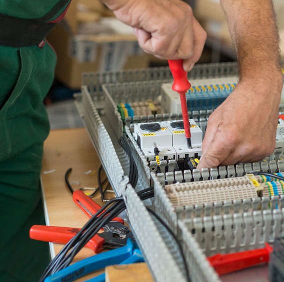 Elektriker schraubt Kabel.